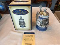 Photo showing the Anheuser-Busch 10th Anniversary Collector's Club Stein alongside its original box and a 2005 Charter Member booklet.
