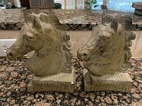 Front view of a pair of horse head bookends showing detailed manes and sculpted features on a rectangular base.
