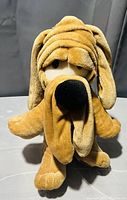 Front view of vintage 1980s Tumbleweeds Laziest Dog plush showing its droopy face folds, floppy ears, and large black nose.