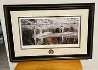 Full view of framed print featuring swans on water with dark frame and matting.