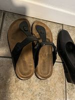 Photo of two pairs of ladies summer shoes, size 8, including black thong sandals and black slip-on flats.