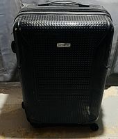 Front view of black Samsonite suitcase showing textured surface and brand logo