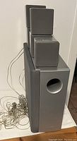 Silver Sony speaker set including satellite speakers and subwoofer with cables
