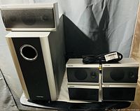 Photo showing the Toshiba subwoofer, center channel speaker, four satellite speakers and a cable.