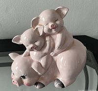 Front angle showing the larger pig with two piglets on its back, smiling faces and detailed painting on eyes and hooves.