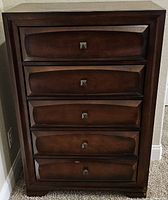 Front view of the brown wood dresser showing five drawers with square metal pull knobs.