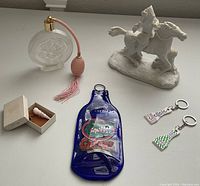 Photo showing all items: limited edition Aldon sculpture, vintage perfume bottle, horse figurine, Gatorade blue bottle decoration, keychains, and small carved piece in box.
