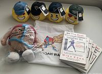 Lot of NFL emoji plush balls with various team caps, Noah Way plush doll, Noah Way T-shirt, and multiple Mike Eden baseball books all new and in good condition.