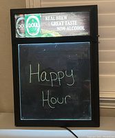 Front view showing illuminated top panel with O'Doul's cans and slogan, and writeable message area displaying 'Happy Hour' in yellow.