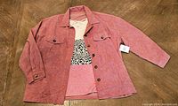 Pink corduroy button-up shirt/jacket with button closure and a pink t-shirt featuring leopard print underneath