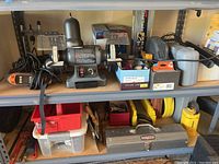 Full view of shelves showing bench grinder, power tool cases, hand tools, toolboxes, and storage bins
