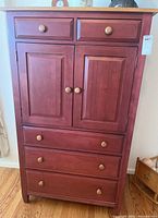 Front view of the tall Ethan Allen dresser showing two top drawers, double door cabinet, and three lower drawers with round wooden knobs.