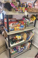 Full view of plastic rack with kids toys, board games, and art supplies on multiple shelves.