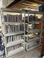 Two heavy duty plastic shelving units holding magazines and papers, showing front view and overall structure.
