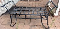 Full view of rectangular black iron bench showing lattice seat and curved legs