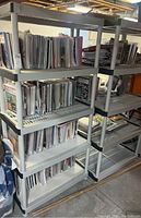 Photo showing two Keter plastic shelving units filled with various papers and stored items in a basement setting.