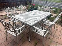 Full view of table and six chairs on brick patio