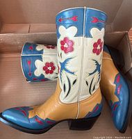 Side profile of both boots in box showing exterior design and stitch details