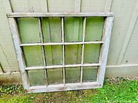 Front view of the antique 12 pane wooden window frame showing all glass panes and weathered paint.