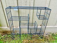 Full front view of the black metal wire storage rack showing the rectangular frame and multiple compartments.