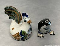 Photo showing both pottery chicken figurines together for size comparison.