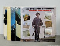 Five vinyl records standing next to each other showing their album covers including Johnny Cash and Stompin' Tom Connors.