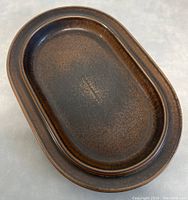 Top-down view of the oval platter showing the full surface and brown speckled glaze