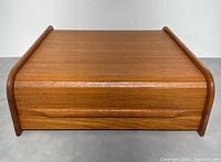 Front view of the teak tambour organizer with roll-top door closed