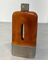 Front view of the flask showing the leather cover and glass viewing window.