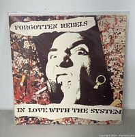 Front album cover of vinyl record In Love With the System by The Forgotten Rebels with artistic image of a person with cigarette.