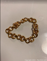 Overall view of circular goldtone link bracelet on white background