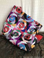 Folded view of colorful patchwork quilt showing geometric pattern blocks with appliqued 3D animals