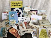 Wide view of the card lot showing assorted sizes and various styles including floral, cartoons, political humor, and novelty cards mainly displayed face up and some partially obscured.