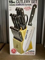 Front view of the 15-piece Santoku cutlery set box showing included items and branding.