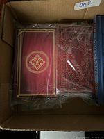 Top view inside box showing two sealed card decks with ornate red and gold patterned backs and a boxed Yahtzee game