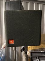Front view of JBL block speaker with fabric cover and orange JBL logo