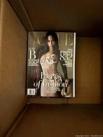 Vogue magazine with lace dress model inside cardboard box