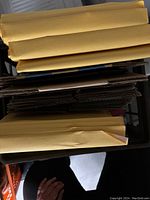 View of padded manila envelopes and cardboard sheets inside milk crate