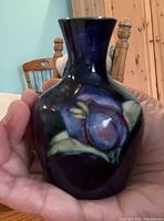Front and side views of the Moorcroft vase displaying floral patterns and dark blue glaze.