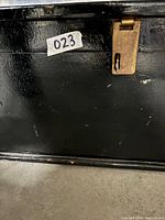 Close-up of black wood trunk showing metal latch and part of the structure.