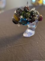 Photo showing multiple vintage rings with gemstone colors including green, blue, yellow and red on a clear ring display stand.