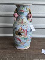 Full view of the porcelain vase showing overall painted lotus and fish design with pomegranate handles and flared rim.