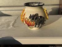 Front view of the ceramic vase showing 3D elephant, large orange flower, and part of a yellow flower