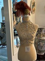 Crystal chest body jewelry displayed on a mannequin showing the full front view and intricate crystal chain design.