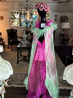 Mannequin wears fuchsia silk and tulle nightgown with green organza robe in elegant room setting.