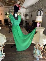 Green lace and chiffon nightgown displayed on mannequin with flowing skirt and lace bodice details.