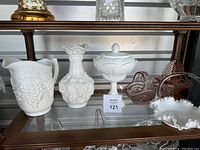 Shelf showing the five vintage glass items as described in the lot.