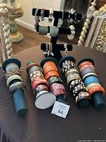 Overview of the various bracelets displayed on stands and rods showing assorted chunky cuffs in multiple colors and materials