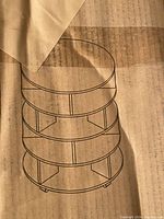 Line drawing of the 4 tier rotating shoe stand structure showing four circular shelves with divided sections supported by vertical legs.