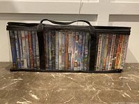 Front side view of DVD cases in carrying case showing titles and condition.